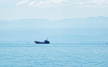 Dry cargo ship on Lake Geneva at Ouchy embankment in Lausanne, Switzerland. People aboard. Mixed media.の写真素材