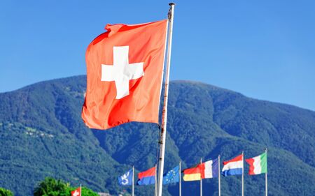 Flags in Ascona, Ticino canton in Switzerland. Swiss Alps on the background. Mixed media.の写真素材