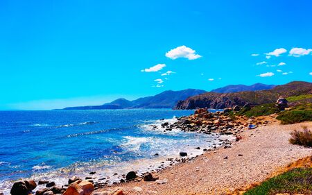 Landscape with Capo Pecora beach at the Mediterranean Sea in Buggerru in South Sardinia of Italy. Scenery Sardinian Italian resort with yellow sand in Sardegna. Mixed media.の写真素材