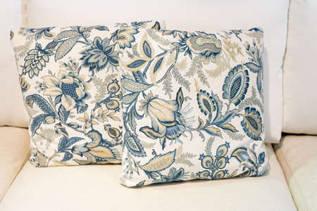 blue floral pattern pillow on white sofaの写真素材