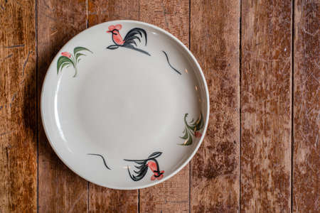 chicken painted thai ceramic plate on wooden backgroundの写真素材
