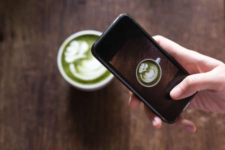 smart phone capturing green tea latte picture