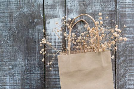 dried flower in paper bag hanging on a wooden wallの写真素材