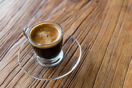 glass shot of espresso on wooden tableの写真素材