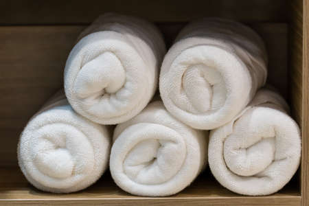 folded white towels in wooden cupboardの写真素材