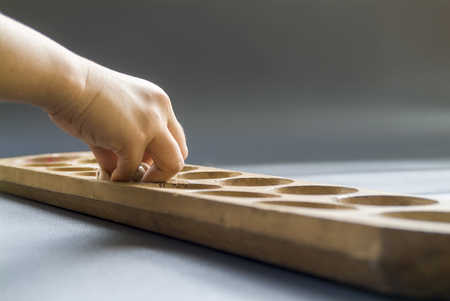 girls took shells from the holes in the congklak game