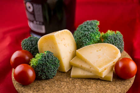 cheese on a plant with vegetables - broccoli and tomatoesの写真素材