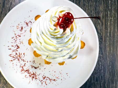 cake with cream and cherry on topの写真素材