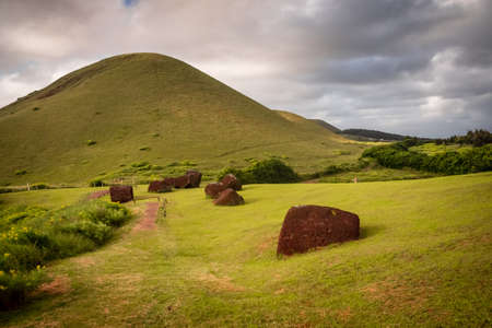 Pukaos quarry in Easter Island, the hats of the moais. Landscape and detail of the red hats of the moais in the quarryの写真素材