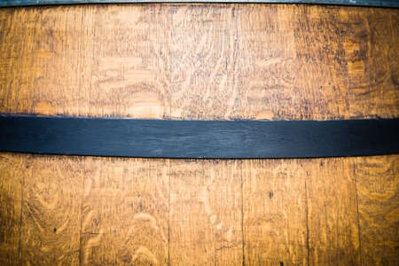 Barrel restoration, a man painting an old wine barrel. Half barrel for plants and garden. Black paintingの写真素材