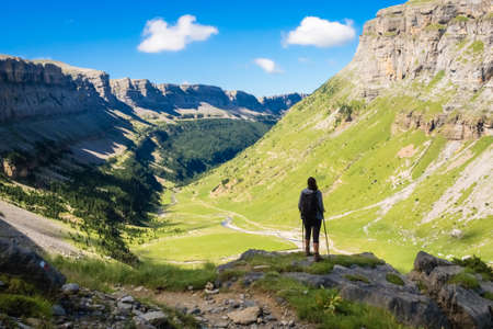 Hiker looking towards the valley of the Ordesa National Park on a sunny dayの写真素材