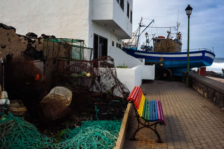 Boat on land during a storm in La Santa in Lanzarote with a rainbow bench. February / 02/2019,...