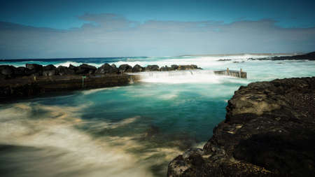 FEBRUARY/02/2019 Waves jumping on dock of the fishing cove of La Santa in Lanzarote during a storm,...