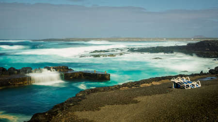 FEBRUARY/02/2019 Waves jumping on dock of the fishing cove of La Santa in Lanzarote during a storm,...