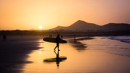 Silhouette of a Surfer on Famara beach at sunset, Canary Island