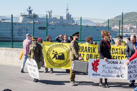 BILBAO, SPAIN - MARCH / 23/2019. People protesting the arrival of the aircraft carrier of the Spanish Navy Juan Carlos I in the port of Bilbao during open day to visit the ship.