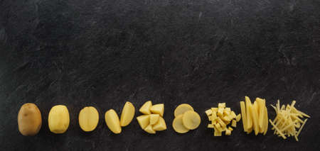 Different cuts of potatoes on a black textured background. Photo taken from aboveの写真素材