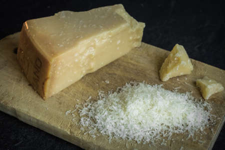 Grated parmesan cheese on black background, italian food. Dark foodの写真素材