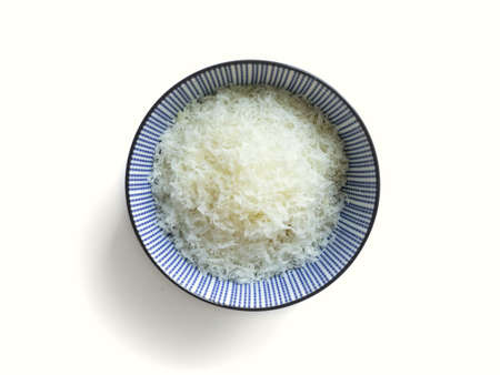 Grated parmesan cheese in a bowl on white background, italian food.