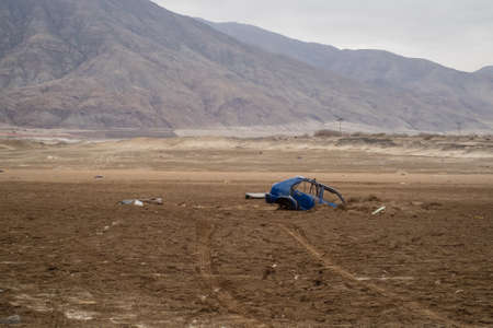 Blue car buried under the earth after a flood in ChaÃ±aral, Chile. Natural disasters