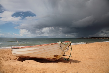 Picture of an old fishing boat on a very cloudy dayの写真素材