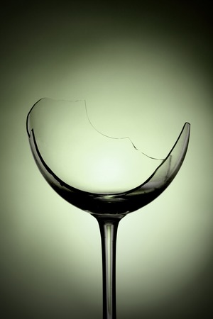 a broken wine glass on a green backgroundの写真素材