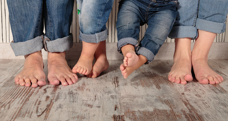 dad, mom and daughters barefoot in jeansの写真素材