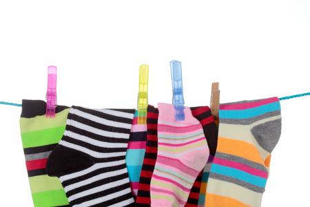 colorful striped socks hanging on a white backgroundの写真素材