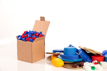 a paperboard box with a lot of caps for recycle on a white background