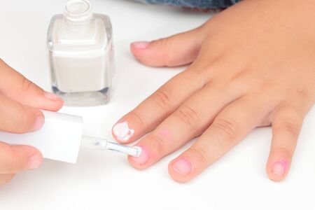 a little caucasian girl painting her nailsの写真素材