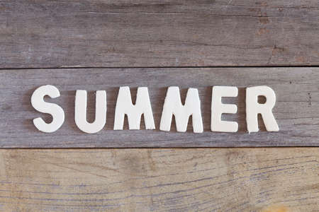 Word summer written with wood letters over a wooden surfaceの写真素材