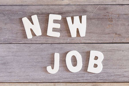 Words new job written with wood letters over a wooden surfaceの写真素材