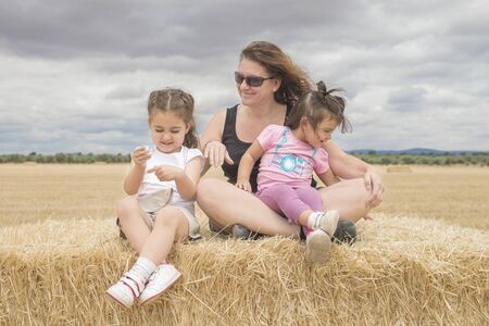 Beautiful caucasian family playing in a straw fieldの写真素材