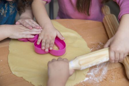 Children hands rolling out dough
