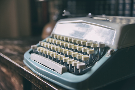 Retro blue typewriter standing on wooden table. Horizontal indoors shotの写真素材