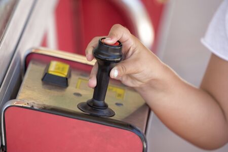 A kid pressing button on joystick. Horizontal outdoors shot