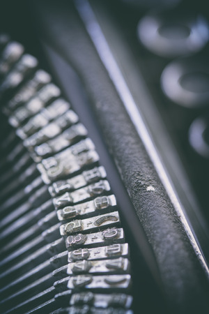 Vertical close-up shot of metal printing letters placed in a typewriter. の写真素材