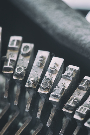 Vertical close-up shot of metal printing letters placed in a typewriter.の写真素材
