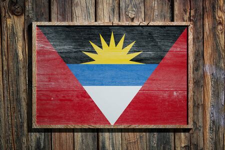 3d rendering of Antigua and Barbuda flag on a wooden frame over a planks wallの写真素材