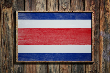 3d rendering of Costa Rica flag on a wooden frame over a planks wallの写真素材