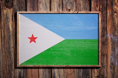 3d rendering of Djibouti flag on a wooden frame over a planks wallの写真素材