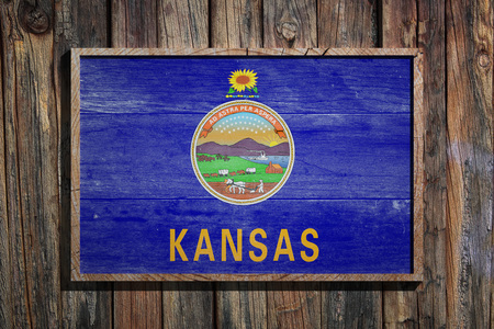 3d rendering of a Kansas State USA flag on a wooden frame and a wood wallの写真素材