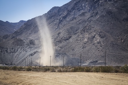 Dust devil blowing dust in to the air on a hot day in the desert.の写真素材