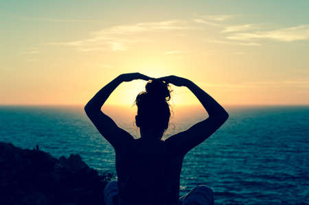 Girl watching sunset on cape San Vicente in Sagres, in the portuguese Algarve. It was taken in June 2016. Photo taken in backlight. Beautiful place and beautiful sunsets from this place, fantastic.の写真素材