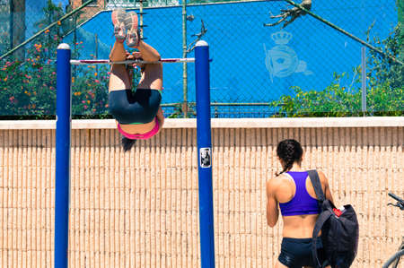 Girl doing sport on a fixed bar on the promenade of Malaga.の写真素材