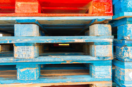 Colorful wooden pallets stacked on top of each other in a factory for stacking fruit boxes.の写真素材