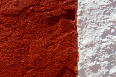 Andalusian house wall with half painted garnet and the other half whitewashed. This wall belongs to...