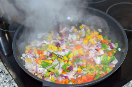 Colorful vegetable cut and prepared to make a stir-fry. Green, red and yellow peppers, purple onion and carrots.の写真素材