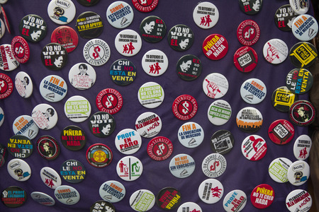 Santiago, Chile - August 18, 2011: Button badges on sale with slogans referring to student demands for better education. Protesters demand the government to improve education quality.のeditorial素材