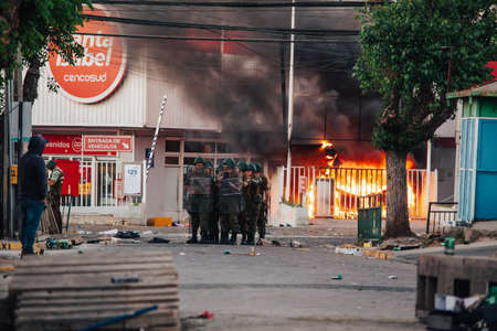 QUILPUE, CHILE - OCTOBER 20, 2019 - Police protect supermarket looted and burned during protests of...